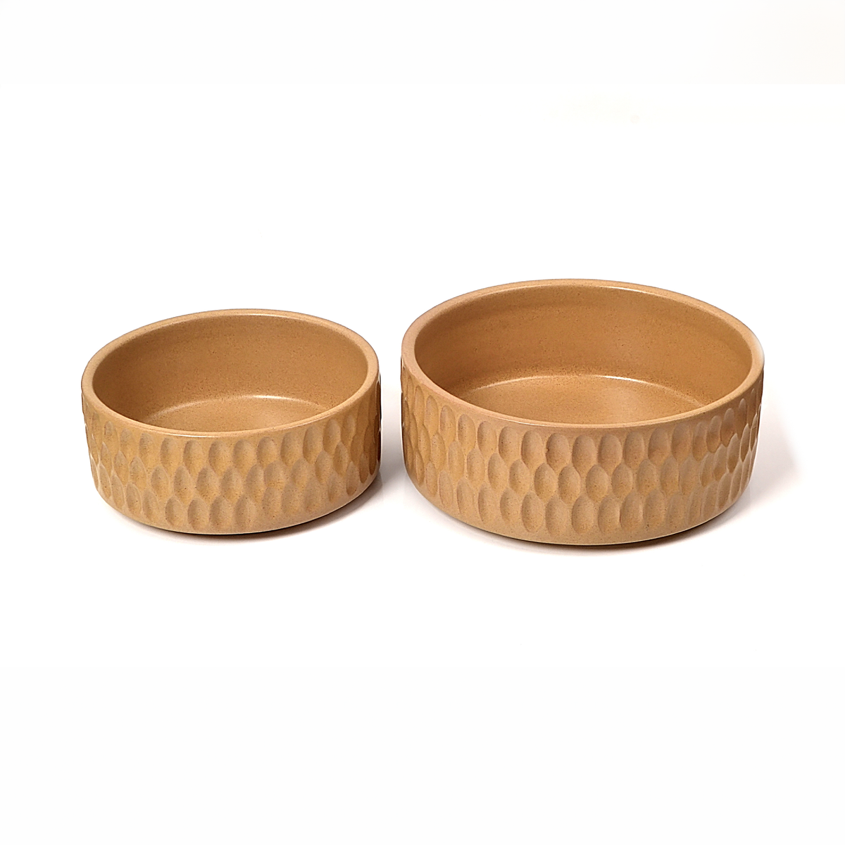 Two round shallow bowls in a warm tan ceramic finish with a textured, dimpled exterior pattern, shown on a plain white background.